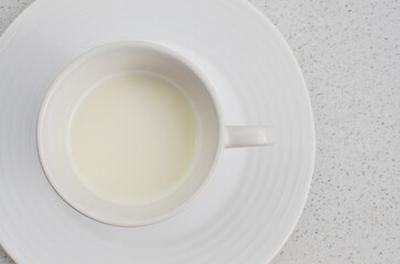 Close-up of the white cup with fresh milk, exuding freshness and readiness to be enjoyed at the table.