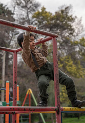 boy playing on playground equipment in a park