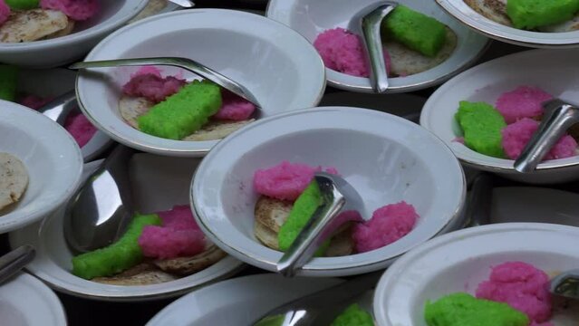 Dawet serabi for buyers at a traditional market. It's traditional Javanese food of rice flour strands curled up into a ball; eaten with coconut milk and palm sugar