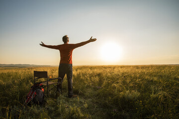 Happy hiker with backpack enjoying view of nature outdoors at sunset. emotional concept adventure summer vacations outdoor hiking