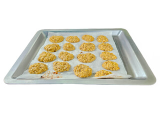 Cookies placed on parchment paper and baking sheet. Isolated on white background.