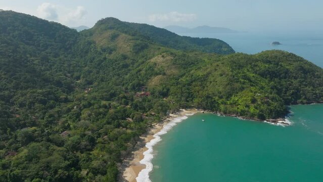 A drone orbits around a paradisaical beach, with golden sandy shores, glistening blue sea, a coastline filled with greenery, abundant trees, and nature. 4k resolution, paradise