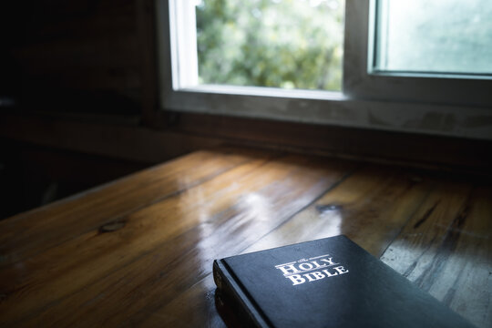 Bible on wooden table with window light  in morning, Preparing to read the Bible for spiritual food, daily manna.