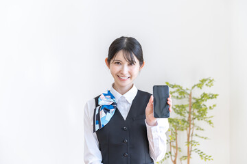 携帯を持つ制服を着た日本人女性