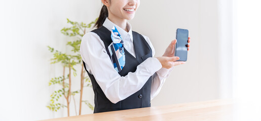 携帯を持つ制服を着た日本人女性