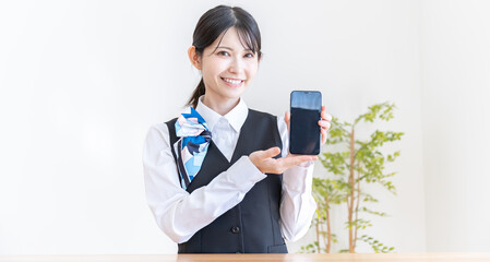 携帯を持つ制服を着た日本人女性