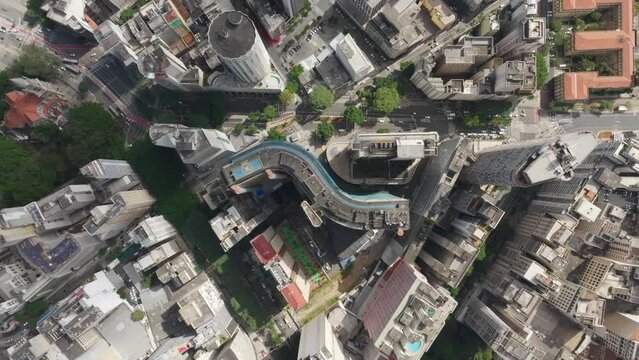 A drone hovers at a 90-degree angle over the center of S&atilde;o Paulo city, revealing iconic buildings below, including the round-shaped Hilton Hotel and the S-shaped Copan Building. Busy avenues filled wi
