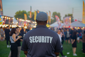 A security guard is controlling the traffic and parking situation at an Asian festival in Canada.