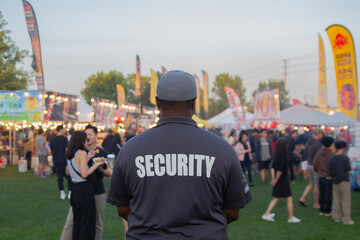 A security guard is controlling the traffic and parking situation at an Asian festival in Canada.