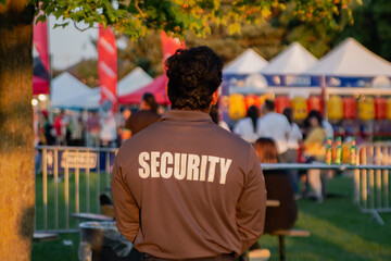 A security guard is controlling the traffic and parking situation at an Asian festival in Canada.
