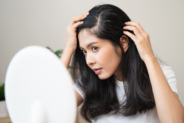 woman looking mirror to find hair problem