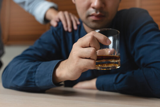 drunk man fall asleep on the table with whiskey glass