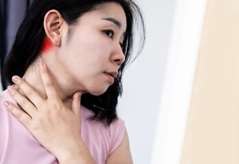 Asian woman suffering from lymphadenitis, lymph node inflammation and feeling pain , swollen behide the ear