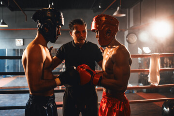Boxer fighter with safety helmet or head guard face off with each other while referee explain rules...