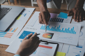 Financial analysts analyze business financial reports on a digital tablet planning investment...