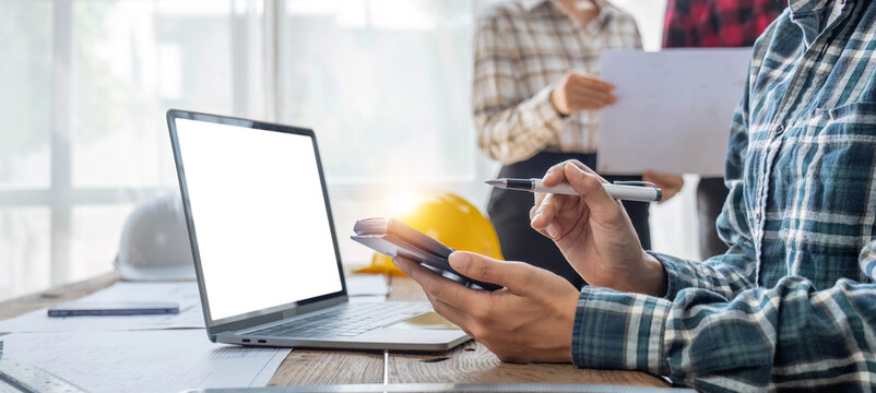 Civil engineer teams meeting working together wear worker helmets hardhat on construction site in modern city. Foreman industry project manager engineer teamwork. Asian industry professional team