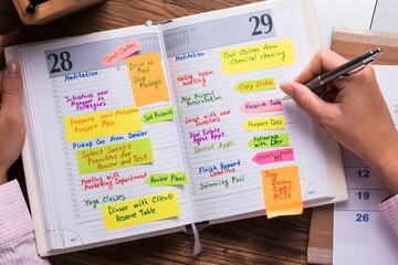 Businesswoman Writing Schedule In Calendar Diary