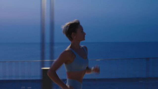 Woman running at nighttime. Young woman run sunrise seaside. Concept of health and lifestyle.