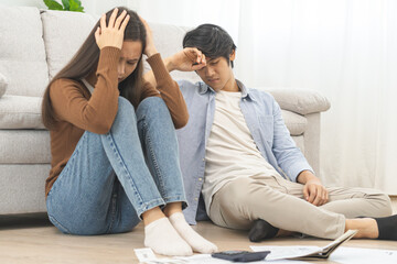 Naklejka na ściany i meble Stressed financial owe asian young couple love sitting suffer, stressed and confused by calculate expense from invoice or bill, no money to pay, mortgage or loan. Debt, bankrupt or bankruptcy people.