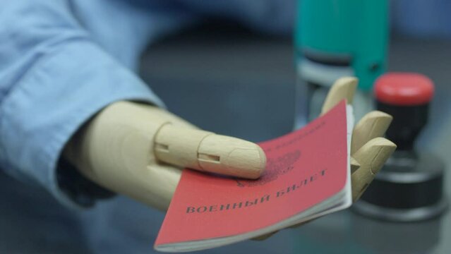 Close Up Arms Of Disabled Employee With Prosthetic Arm Doing Paperwork