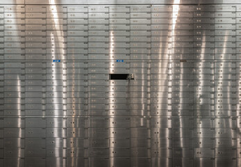 Safe deposit boxes inside bank vault with closed steel doors. Metal deposit lockers, Open deposit box with key, Space for text, Selective focus. - obrazy, fototapety, plakaty
