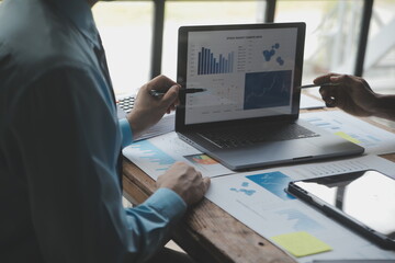 Financial analysts analyze business financial reports on a digital tablet planning investment project during a discussion at a meeting of corporate showing the results of their successful teamwork.