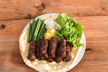 Swek Of Beef Kebab or meat kabab with bahraini bread tandoori nan, lime and salad served in dish isolated on wooden table top view middle eastern grills food