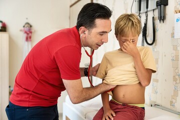 Male Doctor Examining Boy. Pediatrician examining boy patient with stethoscope