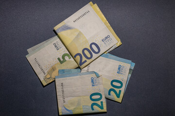 Euro banknotes in 5, 20, and 200 on black bakground