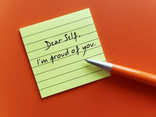Note on orange background with handwritten text DEAR SELF, I'M PROUD OF YOU concept of self- love affirmation - self respect message to boost confidence