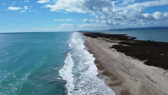 Aerial view of a beach in southern France in summer, bright daylight and a blue sky with some clouds. 