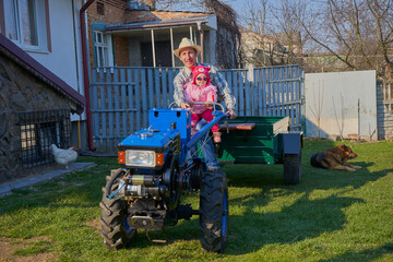 father and daughter on a tractor,a farmer with a little girl sitting on a new tractor
