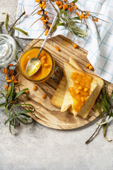 Homemade jelly, toast bread with jam from a sea-buckthorn of an organic sea-buckthorn on a stone...