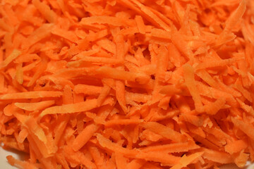 Background of fresh red grated carrots for cooking, close-up