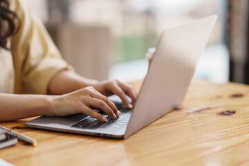 Close-up of hand of businesswoman working using laptop computer.