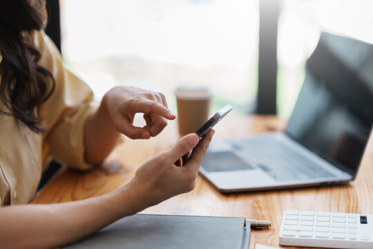 Businesswoman using a smartphone to work on various application including mobile transaction to send messages, LINE, and various business information sent via social media.