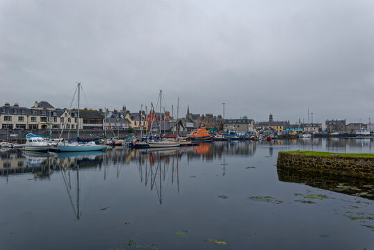 Looking down the waterfront of Stornoway on the Isle of Lewis on an overcast morning, with Yachts and the Lifeboat moored up at Low Tide.