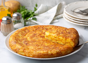 Spanish omelette with potatoes, typical spanish cuisine on gray concrete floor. Tortilla Espanola. Turkish name; Yumurtali patates