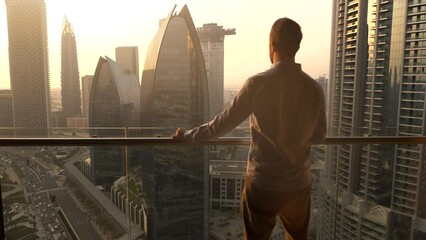 Young Man Succeed In High Rise Apartment Looking at Urban Buildings