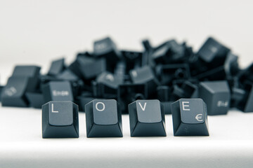 Aus einem Haufen von schwarzen Keyboard-Tasten stechen vier Tasten hervor: "LOVE"