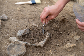 archéologue en train de déterrer un vase du néolithique  - obrazy, fototapety, plakaty