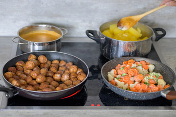 A stove with Swedish meatballs, potatoes, vegetables and brown gravy