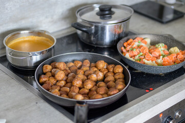 A stove with Swedish meatballs, vegetables and brown gravy