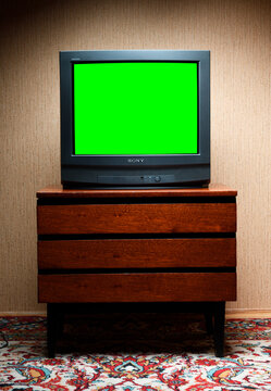 Vintage green screen tv on wooden antique cabinet, old house design. Sony trinitron kv-21m3.