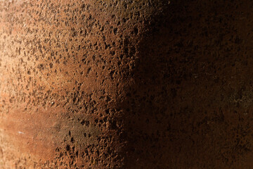 A fragment of an old clay pot. The surface of the ceramic product. Texture. Close-up. The small depth of field