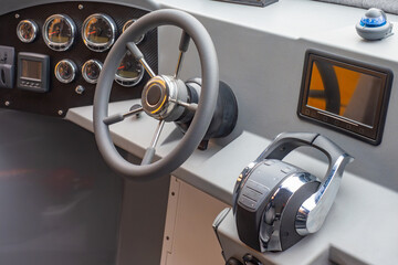 Steering wheel and dashboard of motor boat. Place for captain of sea vessel. Steering wheel for boat control. Yacht control equipment. Steering wheel of small ship. Speedboat for water travel