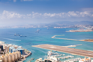 Vista aérea de la pista de aterrizaje  sobre el mar y  del puerto deportivo  sobre el estrecho de...