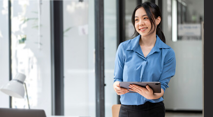 businesswoman standing in office with digital tablet