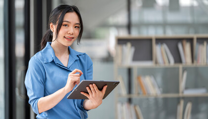 businesswoman standing in office with digital tablet