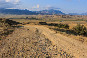 Dirt road leading to a mountain range